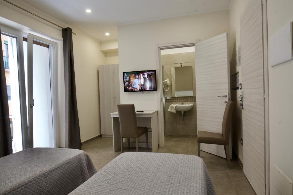Pokój hotelowy z sypialnią z biurkiem i lustrem w obiekcie Six Rooms w mieście Neapol