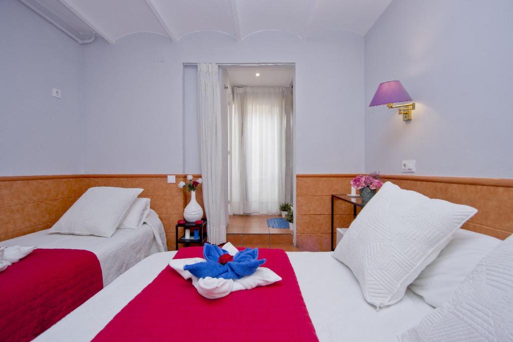 una camera d'albergo con due letti con un fiore blu sul letto di Barcelona City Rooms a Barcellona