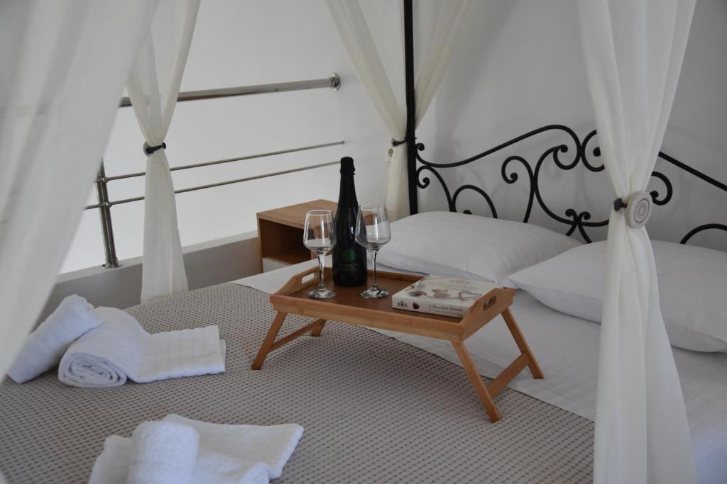 una camera da letto con un letto e un tavolo con bottiglie di vino e bicchieri di Aphrodite's apartment a Galatás