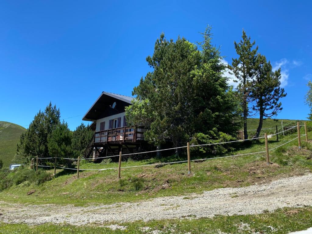 une maison au sommet d'une colline avec une clôture dans l'établissement Chalet Ascou-Pailhères, à Ascou