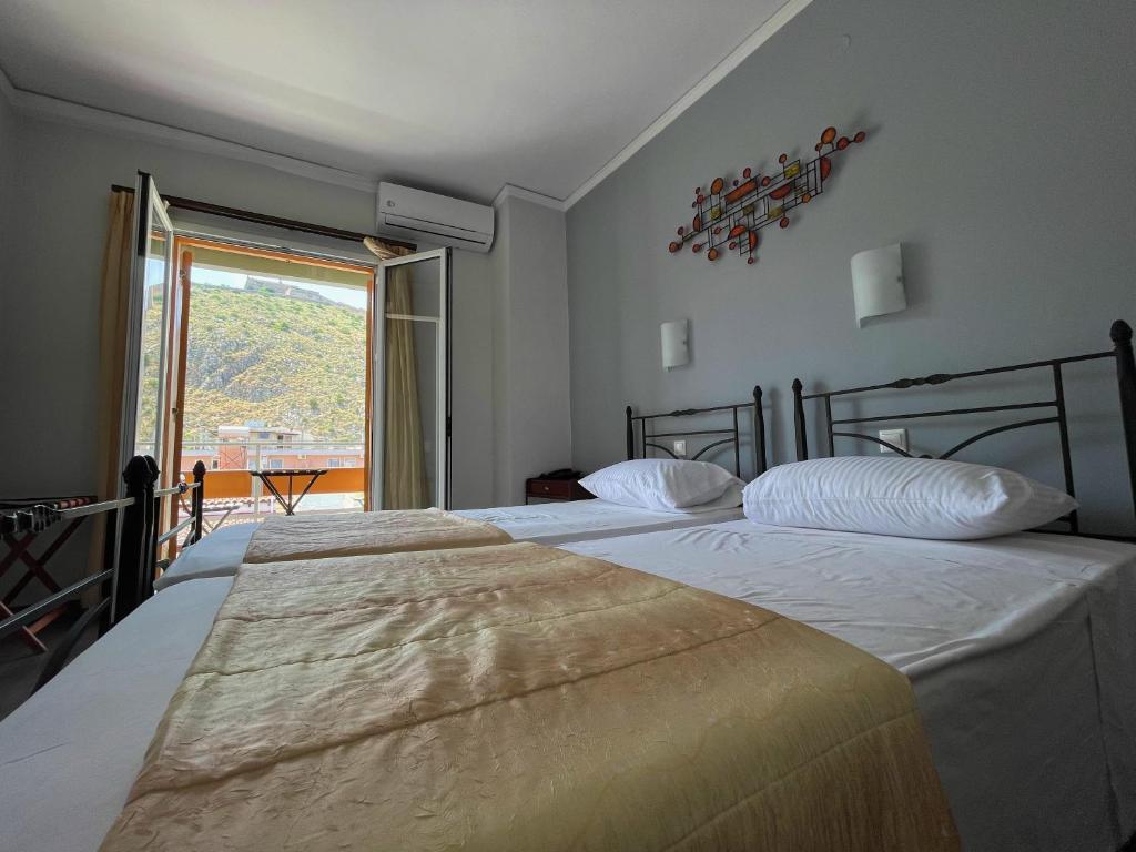 Łóżko lub łóżka w pokoju w obiekcie Nafplia Hotel