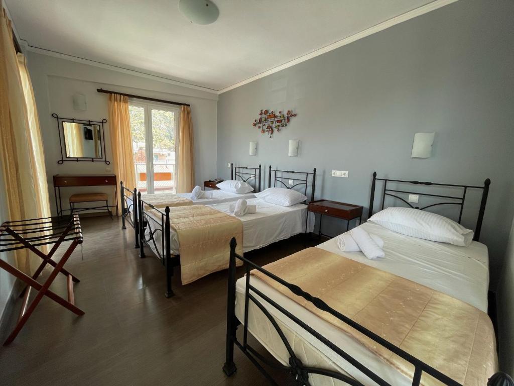 Łóżko lub łóżka w pokoju w obiekcie Nafplia Hotel