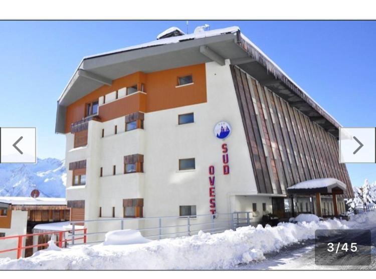 um edifício com neve em frente em Casa 127 em Sestriere