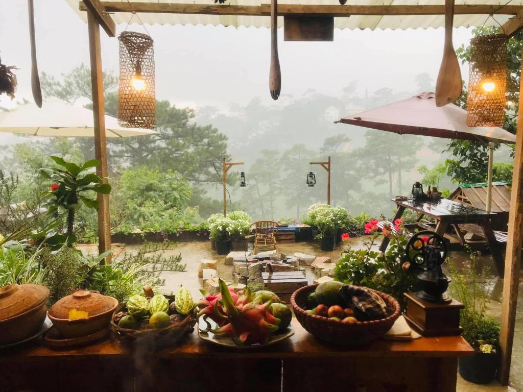 a table with bowls of fruits and vegetables on it at Dalat Memories Homestay - Phố Sương Mờ Đà Lạt in Da Lat
