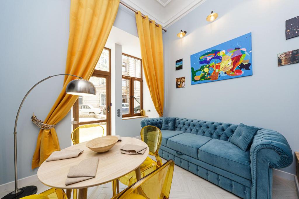uma sala de estar com um sofá azul e uma mesa em Old Town - SELF Check-in em Odessa