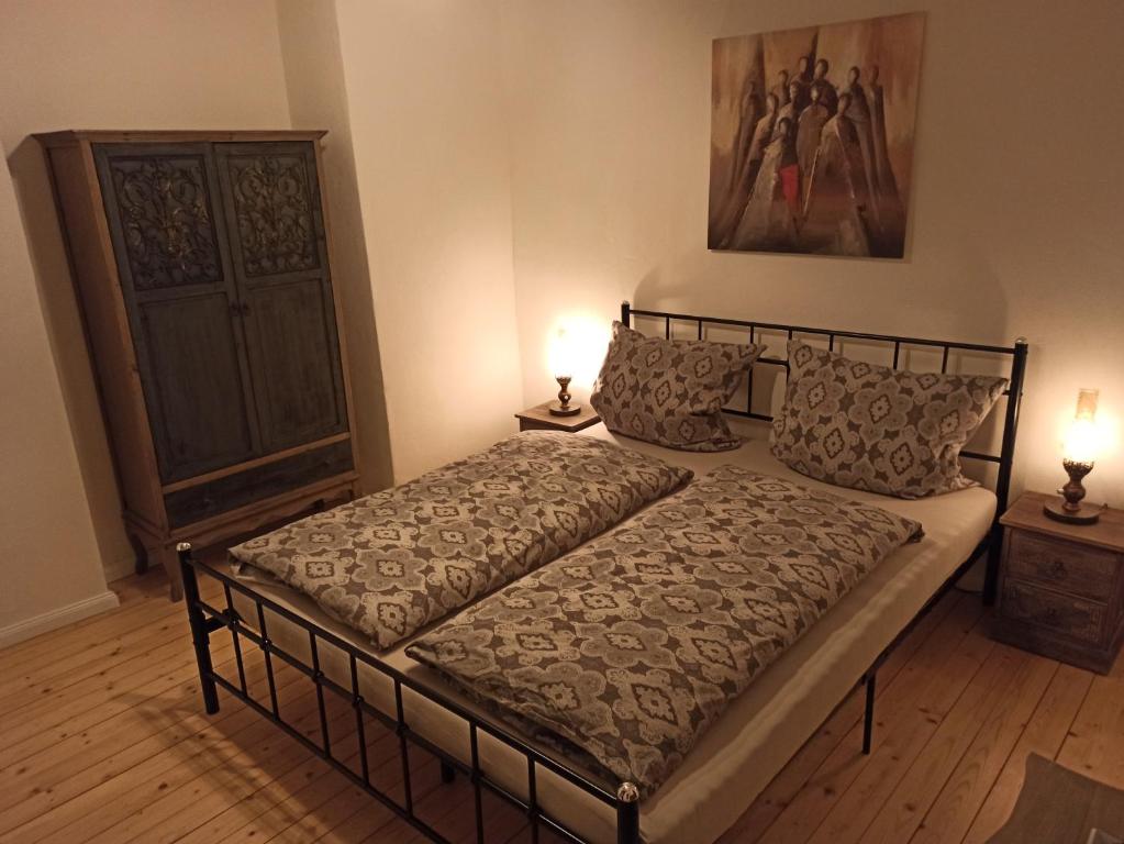 a bedroom with a bed with two lamps on the floor at Alte Schmiede Neustadt in Neustadt an der Weinstraße