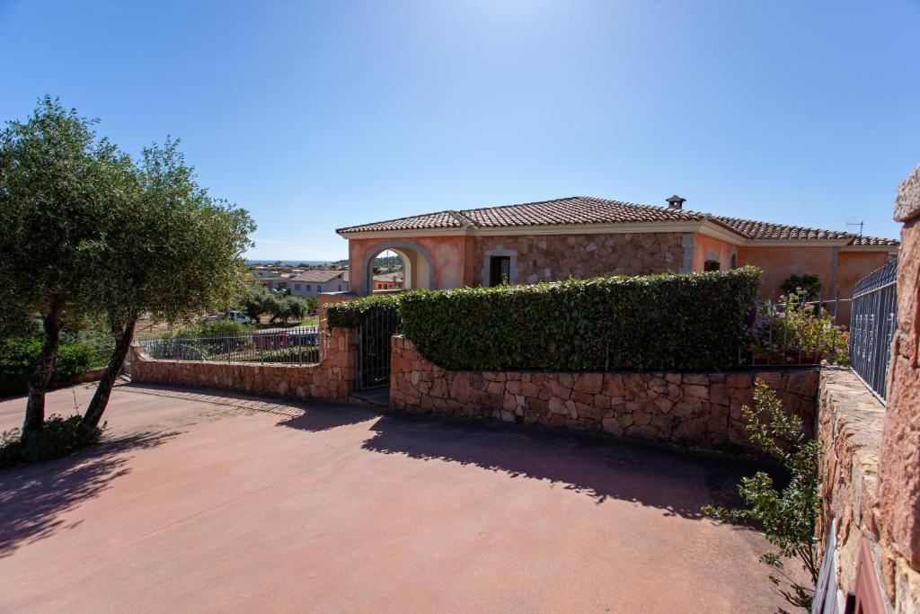 a brick fence in front of a house at Appartamento Belvedere Citai in San Teodoro