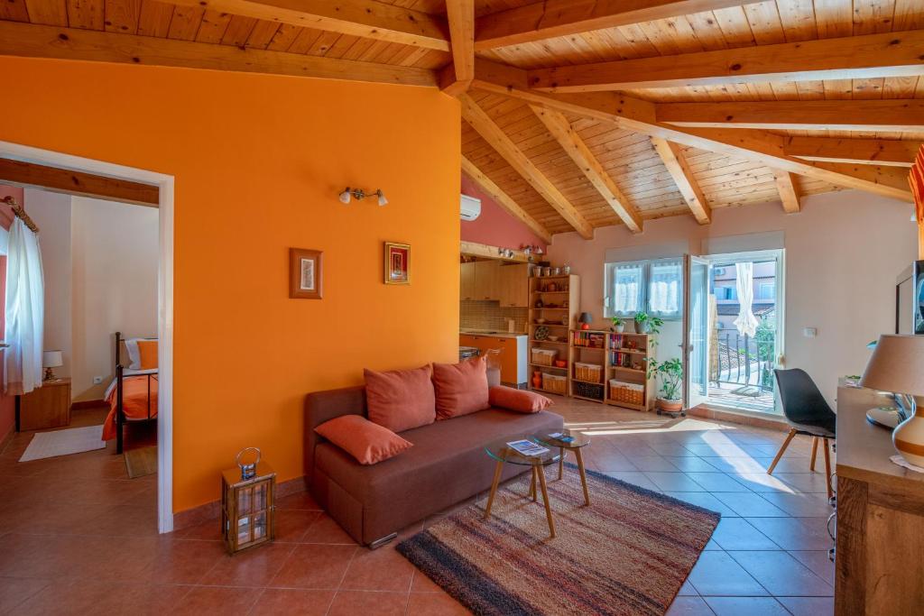 sala de estar con sofá marrón y paredes de color naranja en Apartment Orange 29, en Rovinj