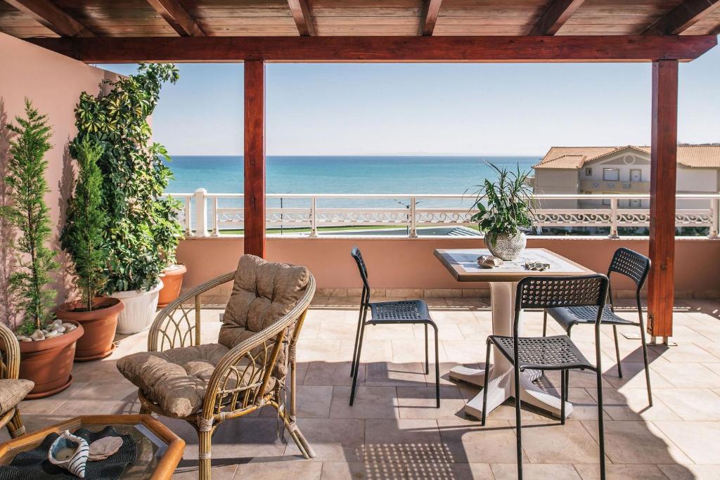 a patio with a table and chairs and the ocean at Level 3 Sea View Studio in Plános