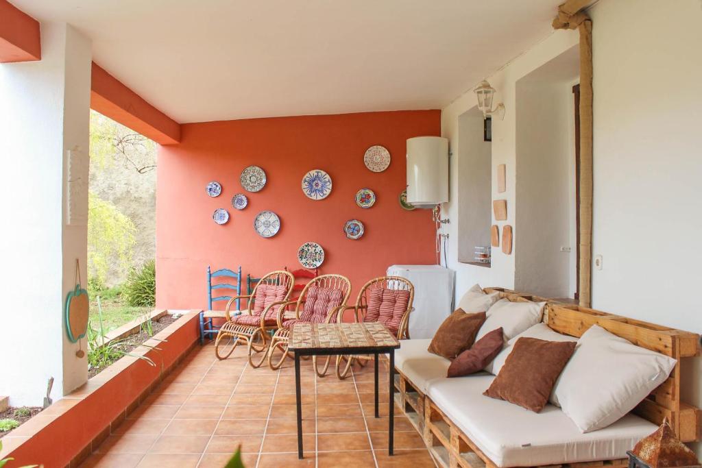 a living room with a couch and a table and chairs at Alojamiento Rural El Gomis in Confrides