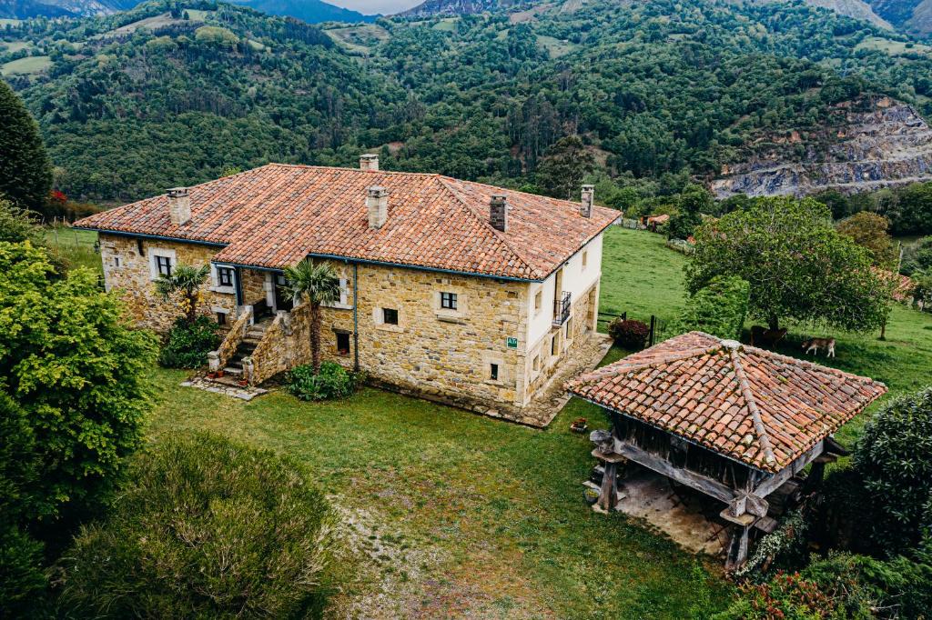 an old stone house in a field with mountains in the background at La Rectoral in Beloncio