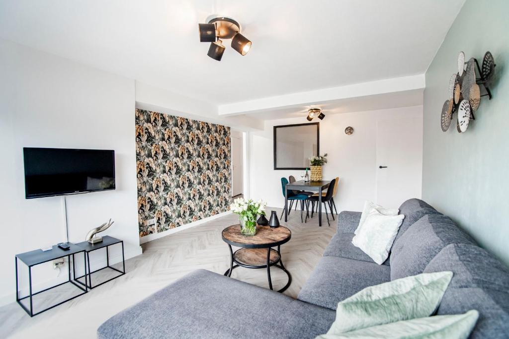 een woonkamer met een bank en een tafel bij Appartement en Studio Papillon in Zandvoort