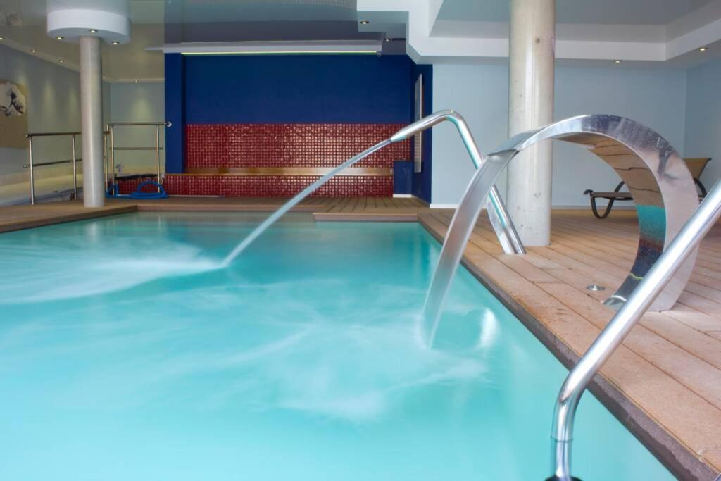 una piscina con un tobogán de agua en un edificio en Centrico apartamento en Noja con acceso a Spa en Noja