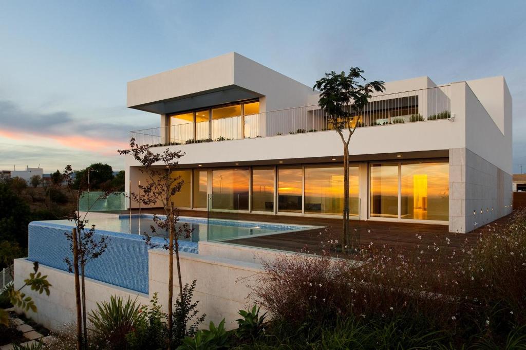 a house with a swimming pool in front of it at Spacious sunset Villa with breathtaking view in Portimão
