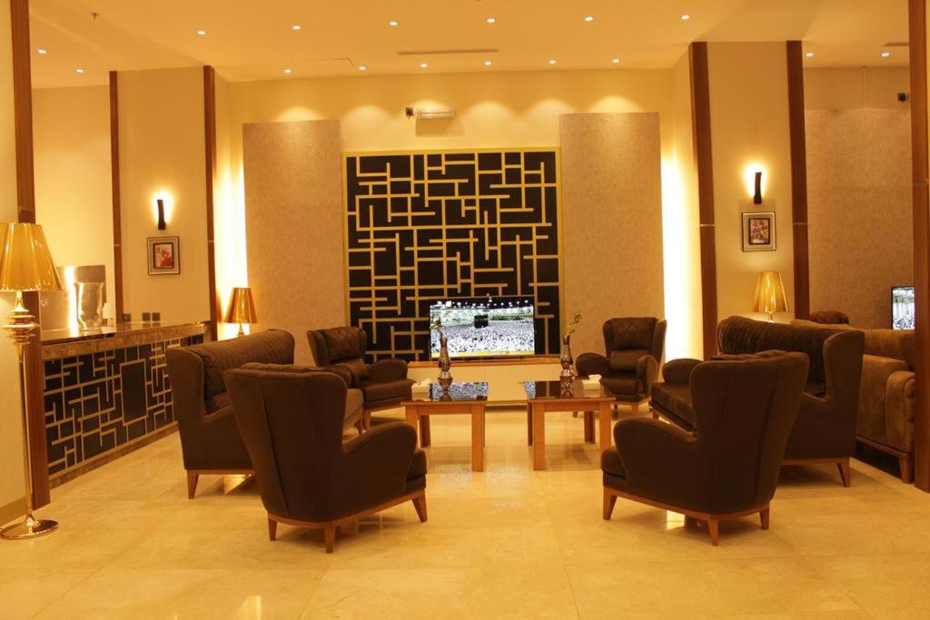 a lobby with a waiting room with chairs and a tv at شقق الفخامة للوحدات السكنية المفروشة in Al Madinah