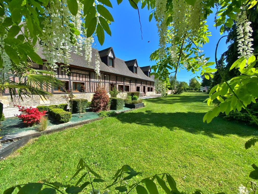 un patio frente a una casa con flores blancas en chambres et gites d'étretat en Étretat