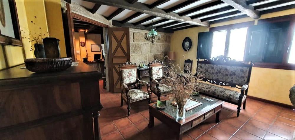 a living room with couches and a table in a room at Hotel A Forxa Cafetería Restaurante in Carballeira