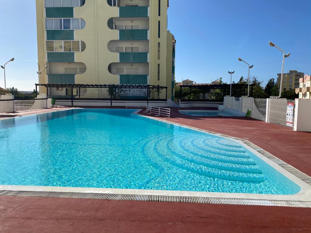 - une grande piscine sur le côté d'un bâtiment dans l'établissement House Amendoeiras , Vila moura, à Vilamoura