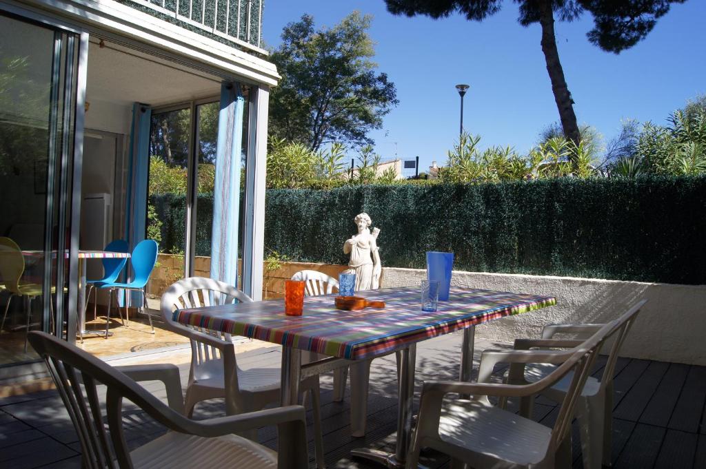 a table with chairs and a statue on a patio at Lara 6 - Grand T2 Terrasse Loggia - WC indép - Parking - Quartier calme entre centre-port et île des Loisirs plage Richelieu in Cap d'Agde
