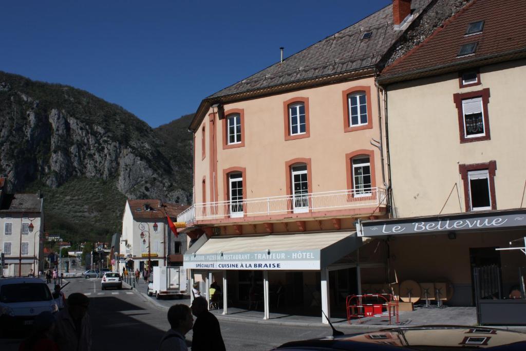 een straat in een stad met gebouwen en een berg bij Hôtel Le Bellevue in Tarascon-sur-Ariège
