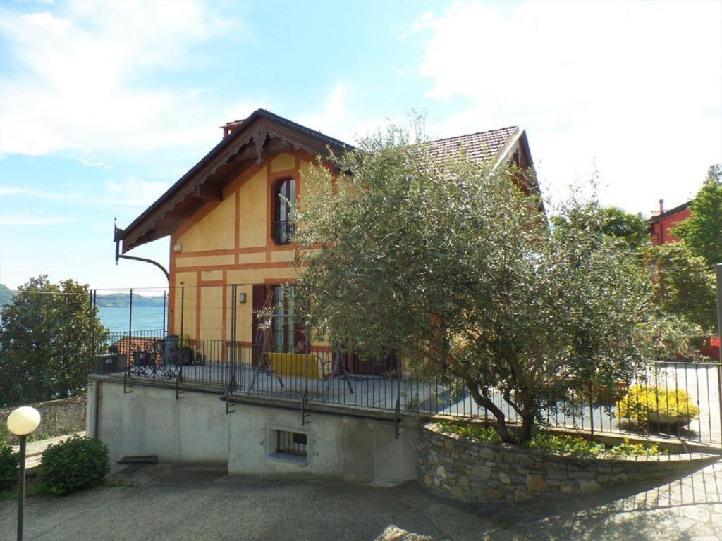 ein gelbes Haus mit einem Zaun und einem Baum in der Unterkunft La Verbanella A in Ghiffa
