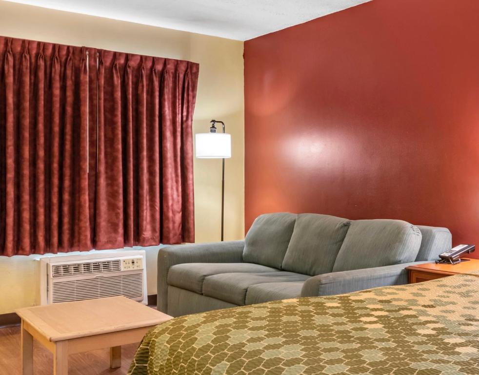 a living room with a couch in a hotel room at Econo Lodge Inn & Suites Maingate Central in Kissimmee