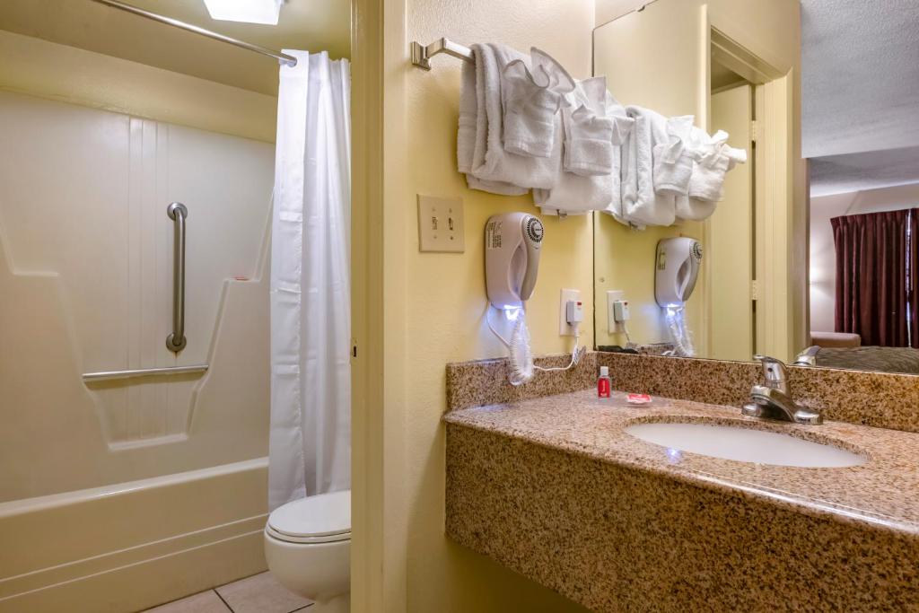 a bathroom with a sink and a toilet and a phone at Econo Lodge Inn & Suites Maingate Central in Kissimmee