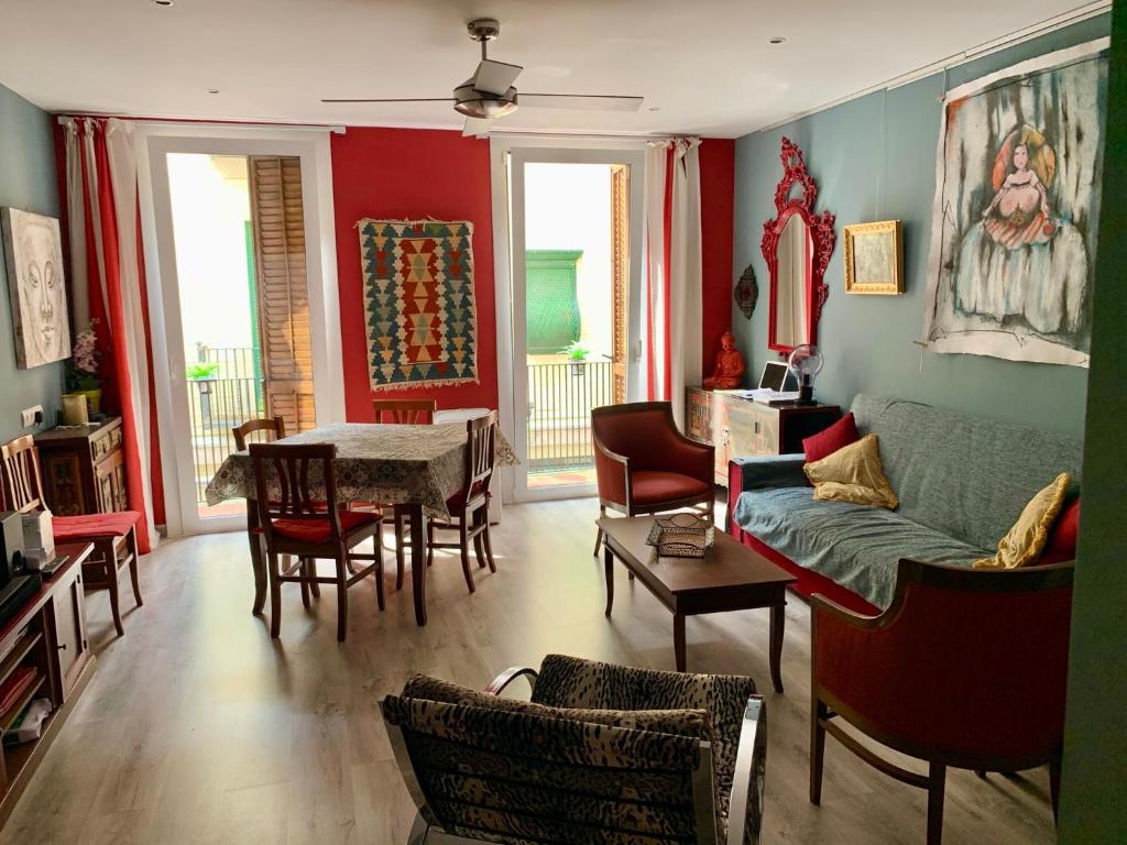 een woonkamer met een bank en een tafel en stoelen bij Duplex ARTE Apartamento Sitges in Sitges
