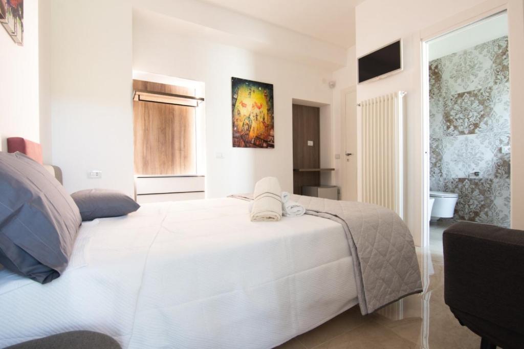 un dormitorio blanco con una cama blanca con zapatos. en B&B IL SOGNO, en Rocca Imperiale