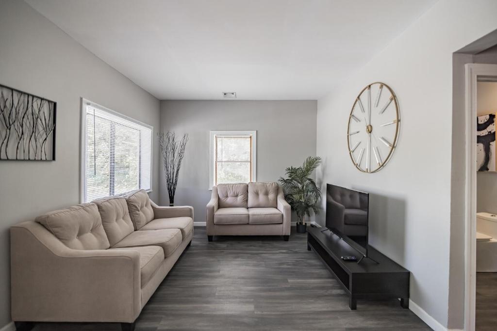 a living room with a couch and a clock on the wall at Modern Coed Dorm 10 mins from Jim Thorpe in Weissport