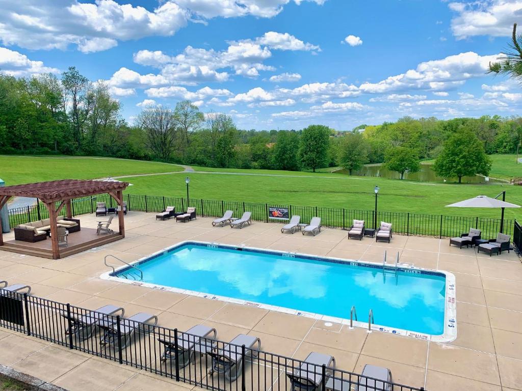 a swimming pool with chairs and a gazebo at The Inn at Hershey Farm in Ronks