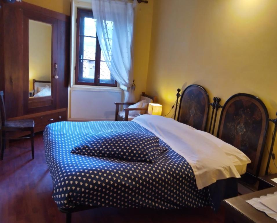 a bedroom with a bed with a blue and white comforter at B&B Fiocco di Neve in Rocca di Mezzo