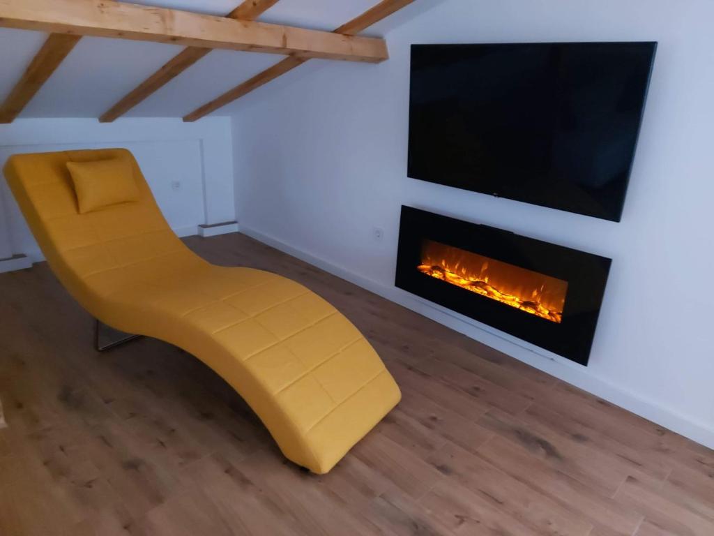 einen gelben Stuhl in einem Zimmer mit Kamin in der Unterkunft Villa Passage in Ohrid