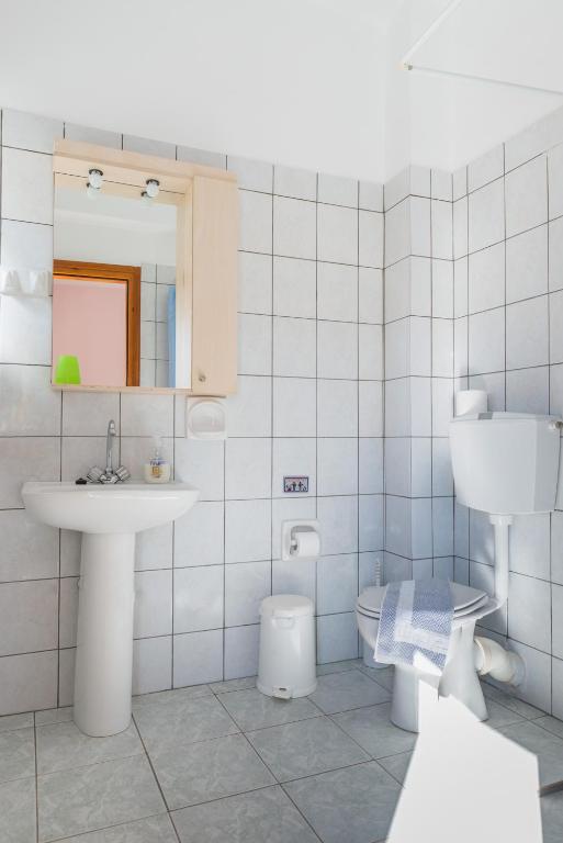 a bathroom with a sink and a toilet at Arsinoi Studios and Apartments in Kalamaki