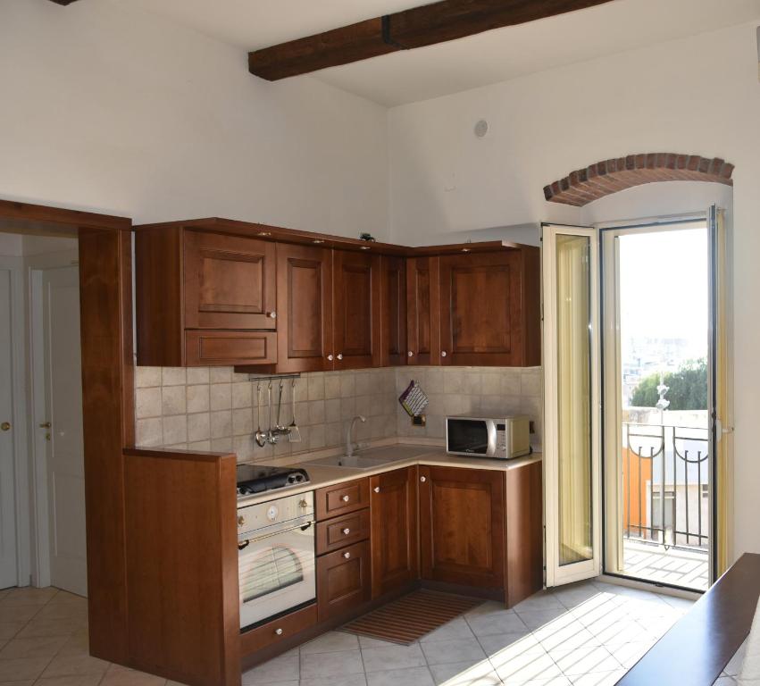 eine Küche mit Holzschränken und einem großen Fenster in der Unterkunft Domida Apartment in Bari