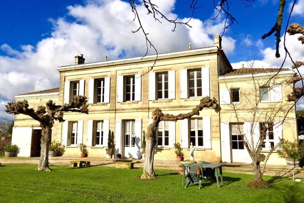 una casa grande con dos árboles delante de ella en Château Roseyrol proche Saint-Emilion, en Saint-Magne-de-Castillon