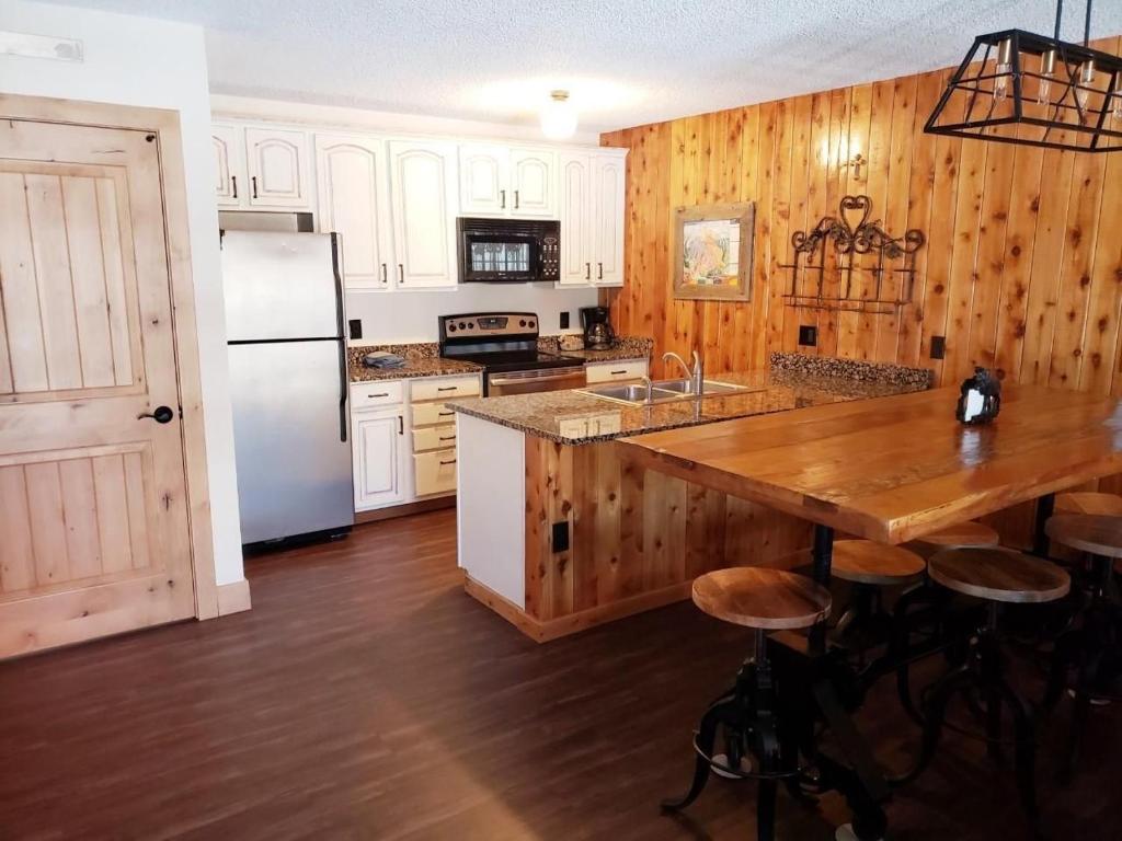 una cocina con paredes de madera y una gran mesa de madera. en Silverado II, en Winter Park