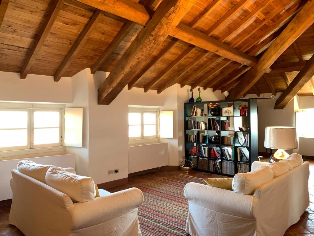 a living room with white furniture and wooden ceilings at Castello di Rocca Grimalda in Rocca Grimalda
