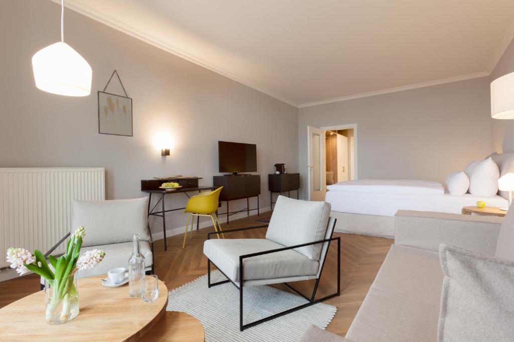 a hotel room with a bed and a table and chairs at Vju Hotel Rügen in Göhren