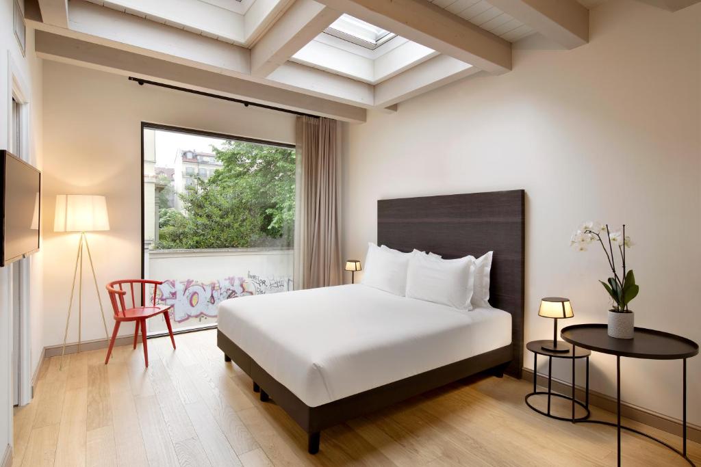 een slaapkamer met een wit bed en een raam bij Opera35 Boutique Hotel in Turijn