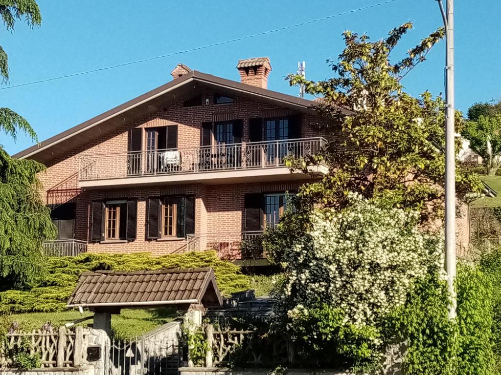 a brick house with a balcony on top of it at VILLA FERNANDO in Castagnole Lanze