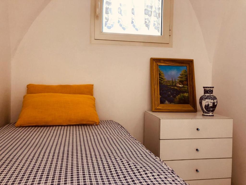 a bedroom with a bed and a painting and a dresser at a Casa dei Sasso in Positano