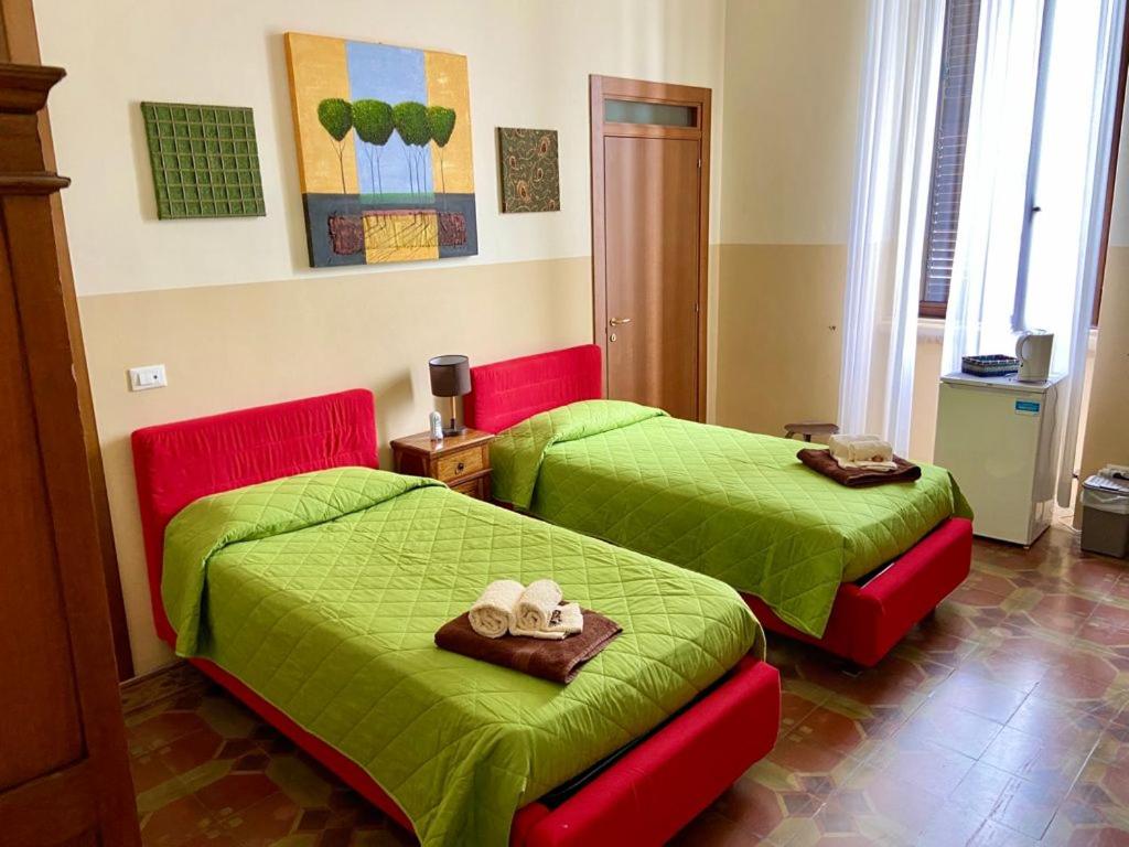 2 łóżka w pokoju z zieloną pościelą i ręcznikami w obiekcie Casa di Marco w mieście Galatina