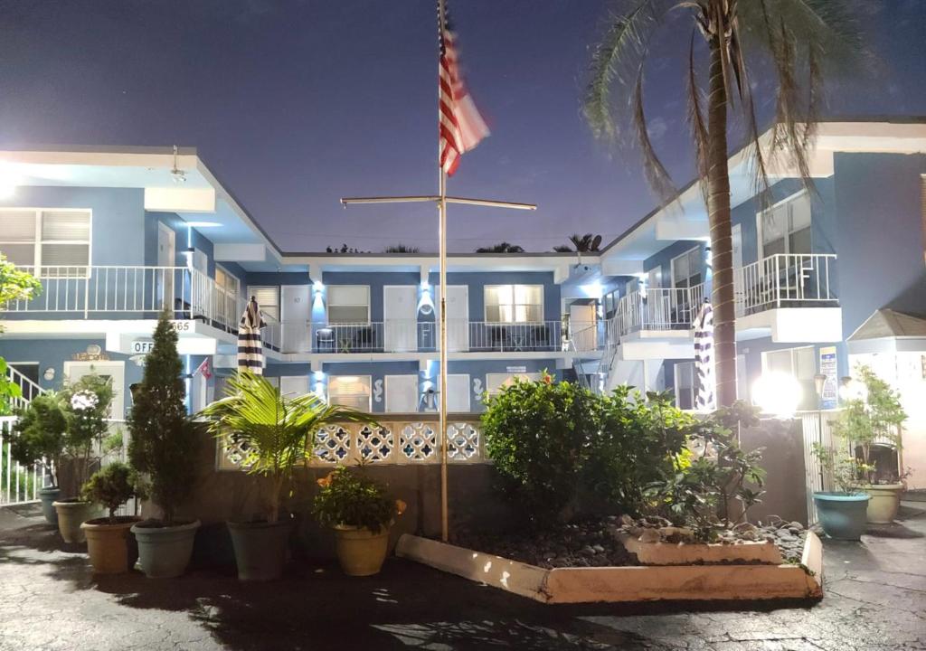 un edificio con una bandera americana delante de él en Ashley Brooke Beach Resort en Deerfield Beach
