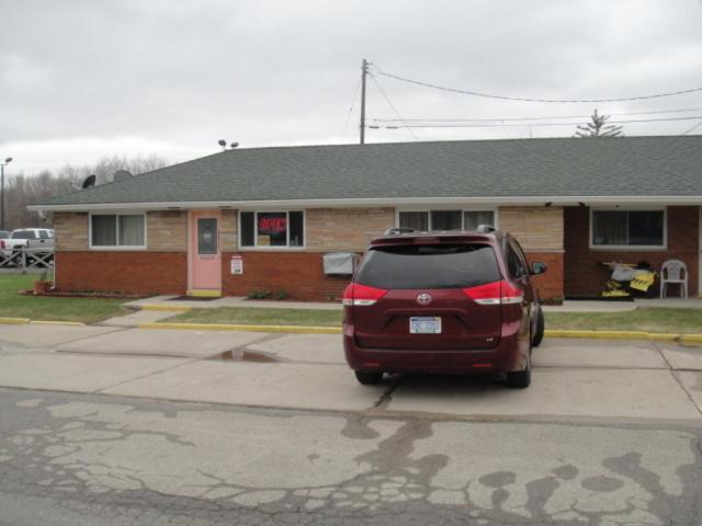 un coche aparcado en un estacionamiento frente a una casa en Standish Motel en Standish