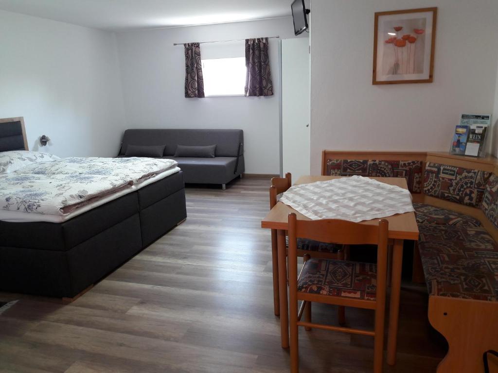 1 dormitorio con cama, mesa y sofá en Ferienwohnung Schwarzbauer en Illmitz