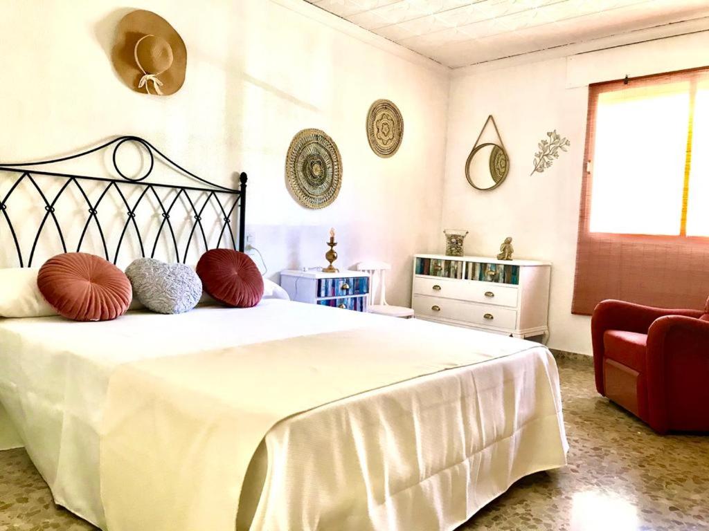 a bedroom with a large white bed with red pillows at Ca Àngela in Bolulla