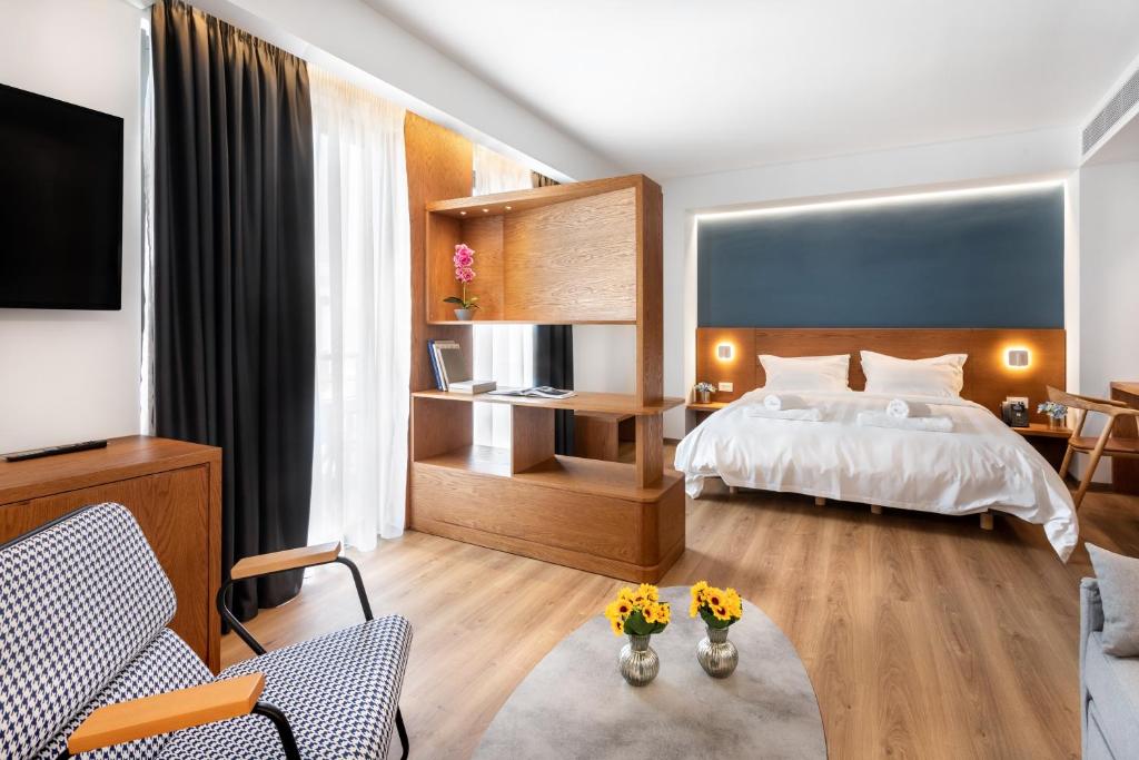 1 dormitorio con 1 cama y sala de estar en DAYS City Suites, en Patra