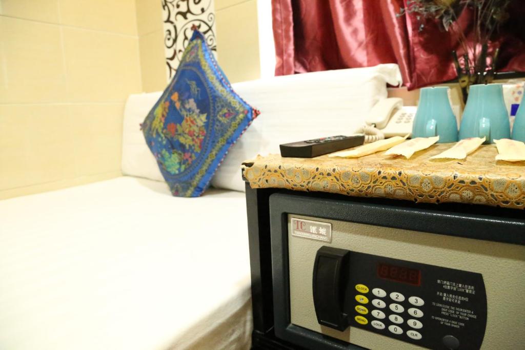 a microwave sitting next to a bed with a pillow at Everest Inn Guest House in Hong Kong