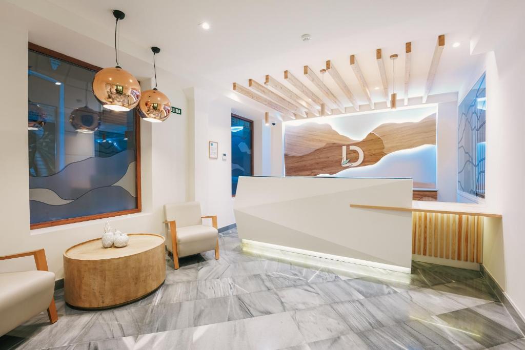 a lobby with a reception desk and chairs at Debambú Atarazanas in Málaga